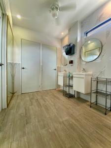 a bathroom with a door and a sink and a mirror at Barrio Inn Padre Mier Hostal & Suites in Monterrey