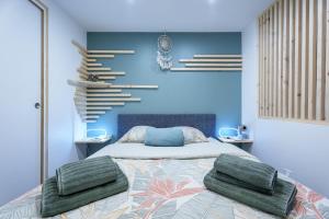a bedroom with a bed with two green towels on it at Studio cosy Allevard in Allevard