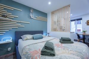 a bedroom with two beds and a blue wall at Studio cosy Allevard in Allevard