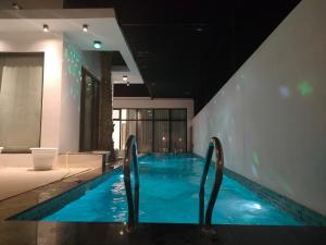 a swimming pool with blue water in a building at Alpha Holiday Home in Barka