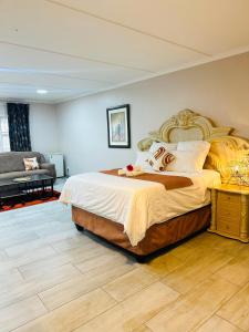 a bedroom with a large bed and a couch at Sharks View in Port Shepstone