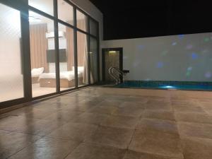 a bathroom with a swimming pool in a building at Alpha Holiday Home in Barka +3 photos
