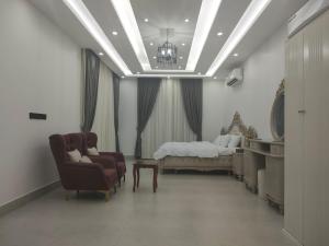 a bedroom with a bed and a couch and a chair at Alpha Holiday Home in Barka