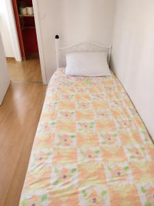 a bed with a quilt on it in a room at Private Room Pré-Saint-Gervais in Le Pré-Saint-Gervais