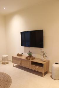 a living room with a flat screen tv on a wall at Monte do Raposo Country House in Monte da Pedra Alva