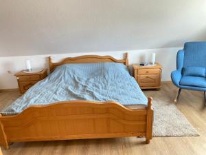 a bedroom with a wooden bed and a blue chair at Walatoll in Norden