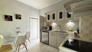 a kitchen with white cabinets and a table and a sink at Folini House in Magaziá +12 photos