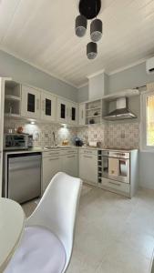 a kitchen with white appliances and a table and a ceiling at Folini House in Magaziá