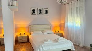 a bedroom with a white bed and two lamps at Folini House in Magaziá
