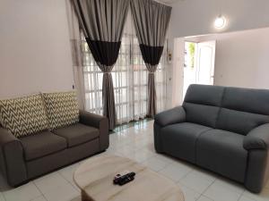 a living room with two couches and a coffee table at SS Ipoh Comfort Homestay - Taman Bertuah in Ipoh