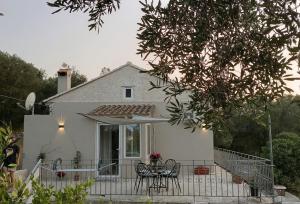 a white house with a table and chairs and an umbrella at Folini House in Magaziá