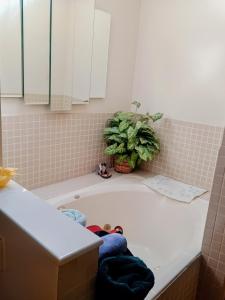 a bathroom with a tub with a person laying in it at WELCOME TO My COTTAGE in Sunland