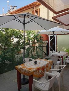 a table and chairs with an umbrella on a patio at Agape’s apartment in Anaxos +1 photo