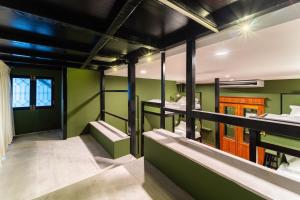 a room with green walls and bunk beds at Versailles Backpacker Hostel in Pondicherry