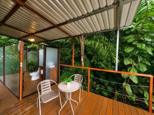 a patio with a table and chairs on a deck at Nido de Cristal con Jacuzzi y AC in Agua Azul
