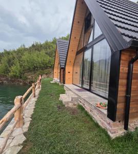 a row of houses on the shore of a river at Mrizi i Drinit in Arrëz
