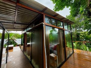 a house with glass doors on a wooden deck at Nido de Cristal con Jacuzzi y AC in Agua Azul +5 photos
