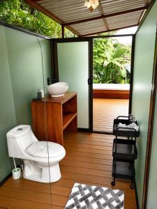 a bathroom with a toilet and a sink at Nido de Cristal con Jacuzzi y AC in Agua Azul