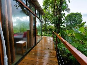 a balcony of a house with a wooden floor at Nido de Cristal con Jacuzzi y AC in Agua Azul