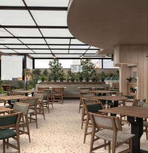 an empty restaurant with wooden tables and chairs at Radisson Hotel Jeddah Tahlia in Jeddah