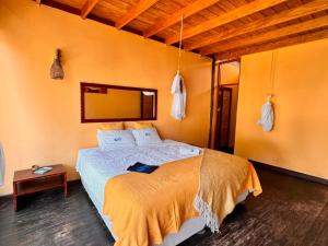 a bedroom with a bed and a mirror on the wall at Kites Mancora in Máncora
