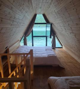 a bed in a room with a large window at Mrizi i Drinit in Arrëz