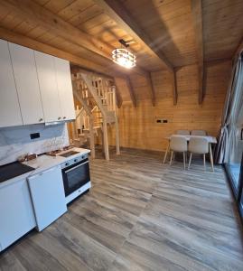 a kitchen with white cabinets and a table with chairs at Mrizi i Drinit in Arrëz