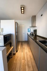 a kitchen with a counter top and a microwave at La ola in Puerto Pirámides