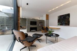 a bedroom with a bed and a living room with a fireplace at A - Luxury Villas in Plomari