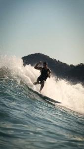 a man riding a wave on a surfboard in the ocean at Mōmento Itamambuca in Ubatuba