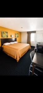 a hotel room with a bed and a chair at ORO North Beach Inn in Corpus Christi