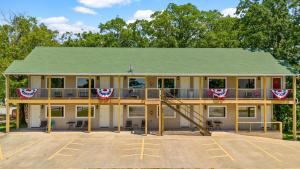 a large house with a porch with a deck at Trailhead Lodge in Eureka Springs