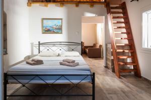 ein Schlafzimmer mit einem Bett und einer Wendeltreppe in der Unterkunft Greg's cottage in Soúrpi
