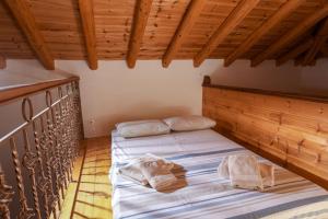 ein Schlafzimmer mit zwei Betten in einem Zimmer mit Holzdecke in der Unterkunft Greg's cottage in Soúrpi
