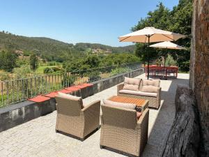 a patio with chairs and a table and an umbrella at Real Villa I by Mycelia in Real