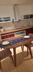 a wooden table with two plates and two glasses on it at Poduszka mini-hotel in Stantsiya Rokitno Volynskoye