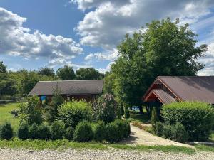 a barn and a house with trees and bushes at Hotel Dudarik in Kosiv