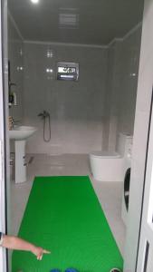 a bathroom with a green mat on the floor at Guest House FAIZ homestay in Panjakent