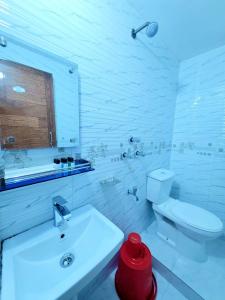 a white bathroom with a toilet and a sink at Coastal daisy Beach resort in Cox's Bazar