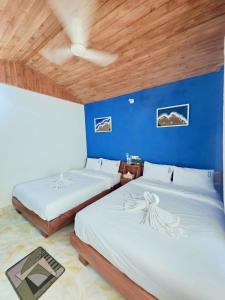 a bedroom with two beds and a blue wall at Coastal daisy Beach resort in Cox's Bazar