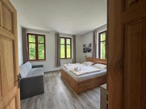 a bedroom with a bed and a couch and windows at Celnice pod Sněžníkem-Nová Seninka in Staré Město
