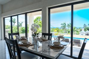 a dining room with a table with a view of a pool at Emotions by Ironshore in Montego Bay