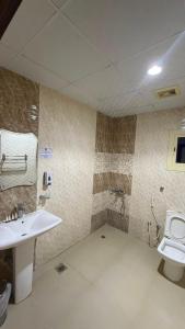 a bathroom with a sink and a toilet at فندق جوهرة الحجاز ريع بخش توصيل من والي الحرم مجاني in An Naqāʼ