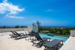 a patio with chairs and a swimming pool at Emotions by Ironshore in Montego Bay