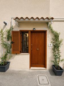 a wooden door of a building with two plants at Il Focolare in Subiaco