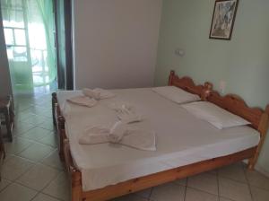 a bedroom with a bed with white sheets and bows at Ariadni Fountas Studios in Parga