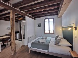 a bedroom with a large bed with wooden beams at Les Nuitées de Bois Renaud Chambre d'Hôtes LA FORET in Marcilly-en-Gault