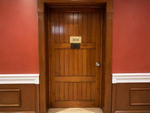 a wooden door with a sign on it at Cavi Rooms 304 in Cuenca +1 photo