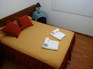 a bedroom with a bed with two towels on it at Hotel Aoma Mar del Plata in Mar del Plata