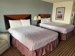 a hotel room with two beds and a couch at Budget Host Inn in Salina